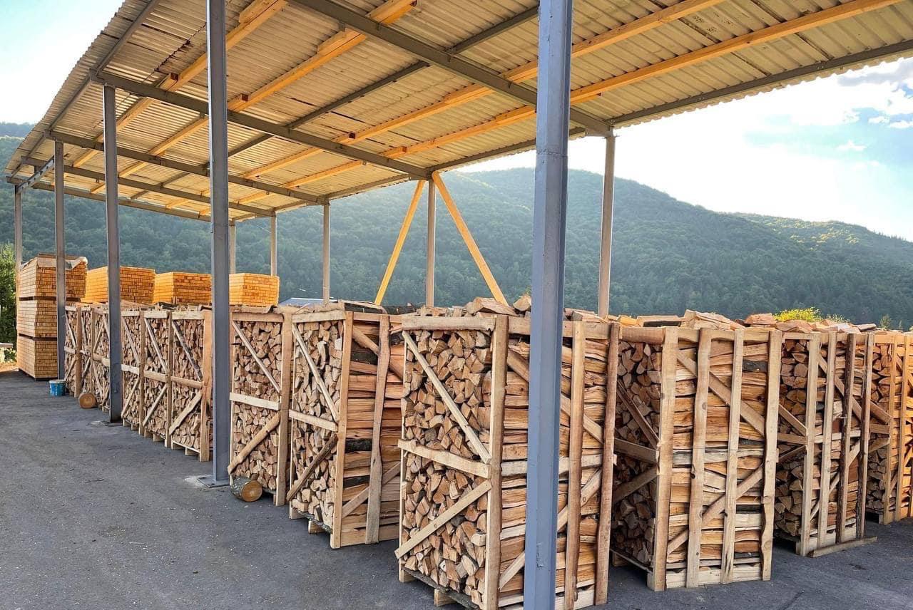 Seasoned split beech and hornbeam firewood logs stacked outdoors